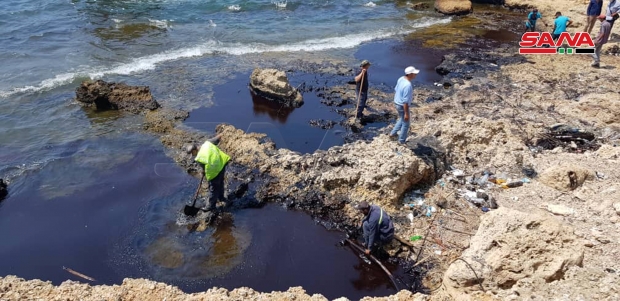 시리아 바니야스 해안에서 기름 제거 작업에 열중하는 주민들