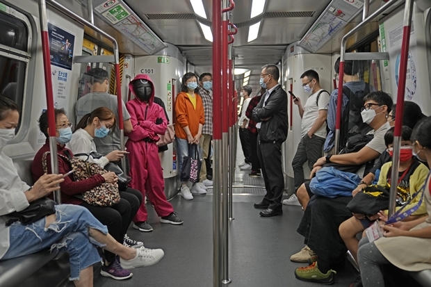 30일 밤 홍콩 지하철의 여성 승객 한 명이 오징어게임 경비원 복장으로 핼러윈의 밤을 향해 달리고 있다./AP연합뉴스