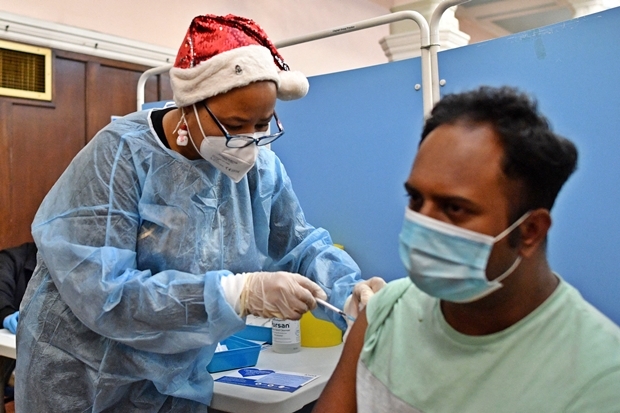 25일(현지시간) 영국 국민보건서비스(NHS) 관계자가 런던 동부 레드브리지에 마련한 임시 접종소에서 코로나19 백신을 투여하고 있다./AFP연합뉴스