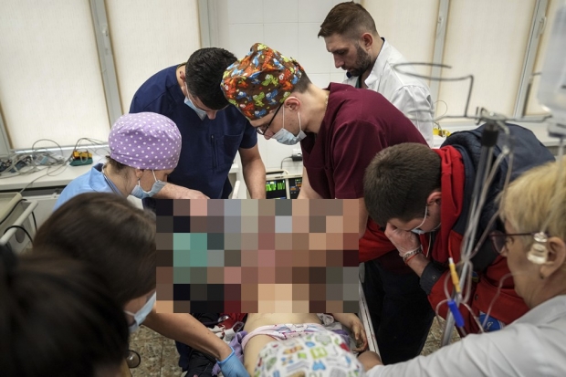 지난 27일 마리우폴 시립병원으로 후송된 어린 소녀를 치료하는 의료진들. 이날 소녀는 안타깝게도 숨졌다. 사진=AP 연합뉴스