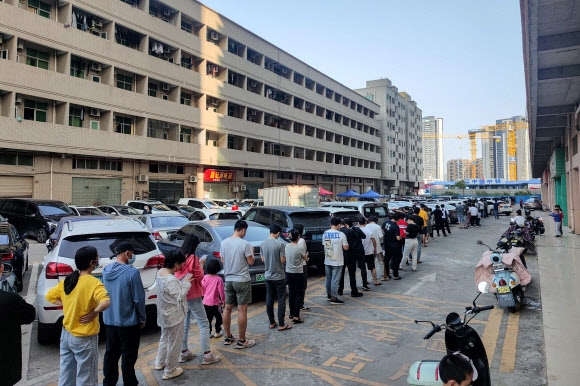 ‘코로나19 재확산 조짐’ 중국 선전시 검사 대기 행렬 - 13일 중국 광동성 선전시 주민들이 코로나19 핵산 검사를 받기 위해 길게 줄지어 서 있다. 인구 1750만 명의 ‘중국 실리콘밸리’로 불리는 선전시는 이날 신규 확진자가 60명 나오자 도시 봉쇄령을 내렸다. 2022.3.14 AFP 연합뉴스