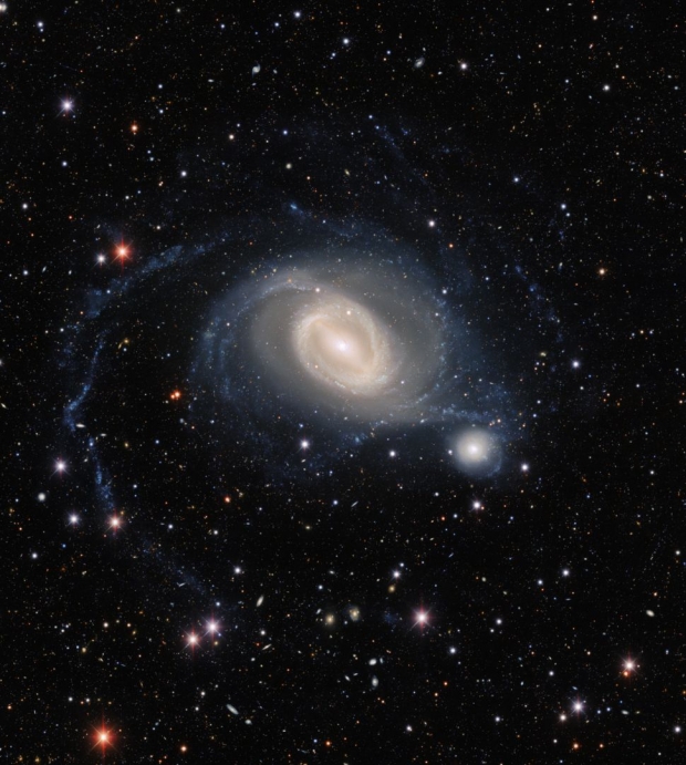 서로의 중력에 얽매여 스치듯이 공전하는 두 은하 NGC 1512와 NGC 1510은 이윽고 서로 합쳐져서 하나의 합병 은하를 만들게 될 것이다. / 암흑에너지 조사
