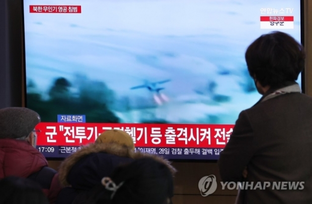 지난 26일 서울역 대합실에서 ‘북한 무인기 영공침범’ 소식 접하는 서울시민들. 연합뉴스