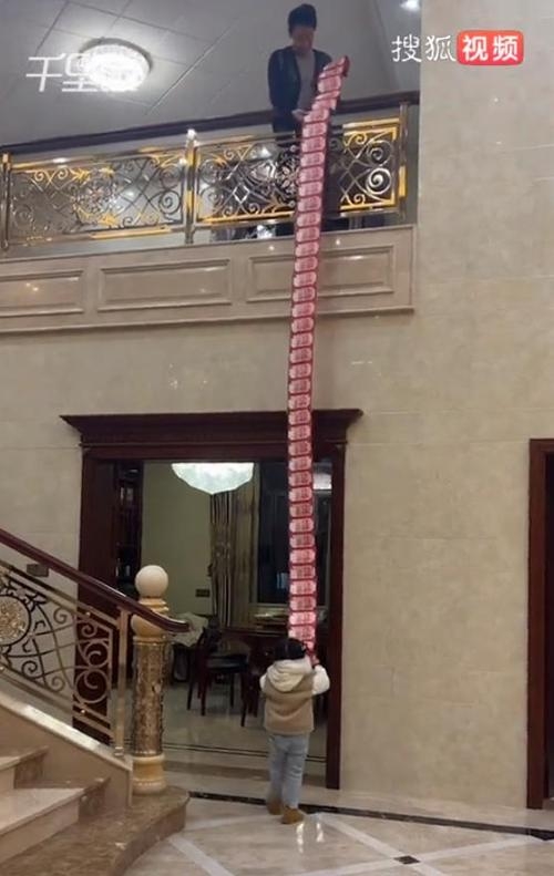 중국 푸젠성의 한 할아버지가 고향을 찾은 손녀를 위해 현금을 줄줄이 연결한 홍바오를 준비해 전달해 화제다. 출처 웨이보