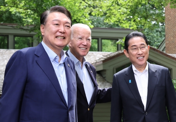 캠프 데이비드에서 밝게 웃는 한미일 정상 - 윤석열 대통령과 조 바이든 미국 대통령, 기시다 후미오 일본 총리가 18일(현지시간) 워싱턴DC 인근 미국 대통령 별장인 캠프 데이비드에서 열린 한미일 정상회의를 앞두고 로렐 로지 앞에서 기념 촬영을 하고 있다.-연합뉴스