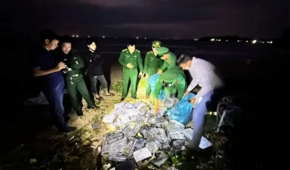 베트남 경찰이 해안가에 떠밀려온 마약 꾸러미를 살펴보고 있다