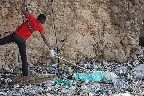 지난 7월 케냐 쓰레기 매립장에서 발견된 시신을 수습하는 남성의 모습 EPA 연합뉴스
