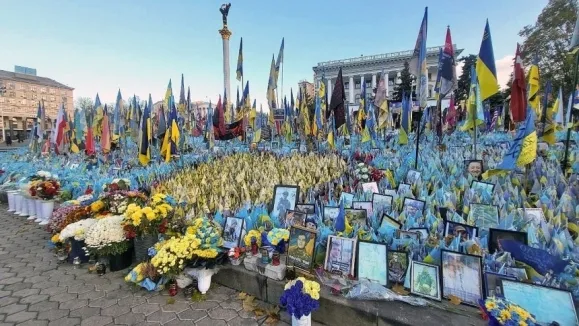 우크라이나 전쟁 발발 1000일을 하루 앞둔 18일(현지시간) 수도 키이우의 독립광장에 전사자들을 기리기 위한 깃발과 사진, 꽃 등이 빼곡히 놓여 있다. 연합뉴스