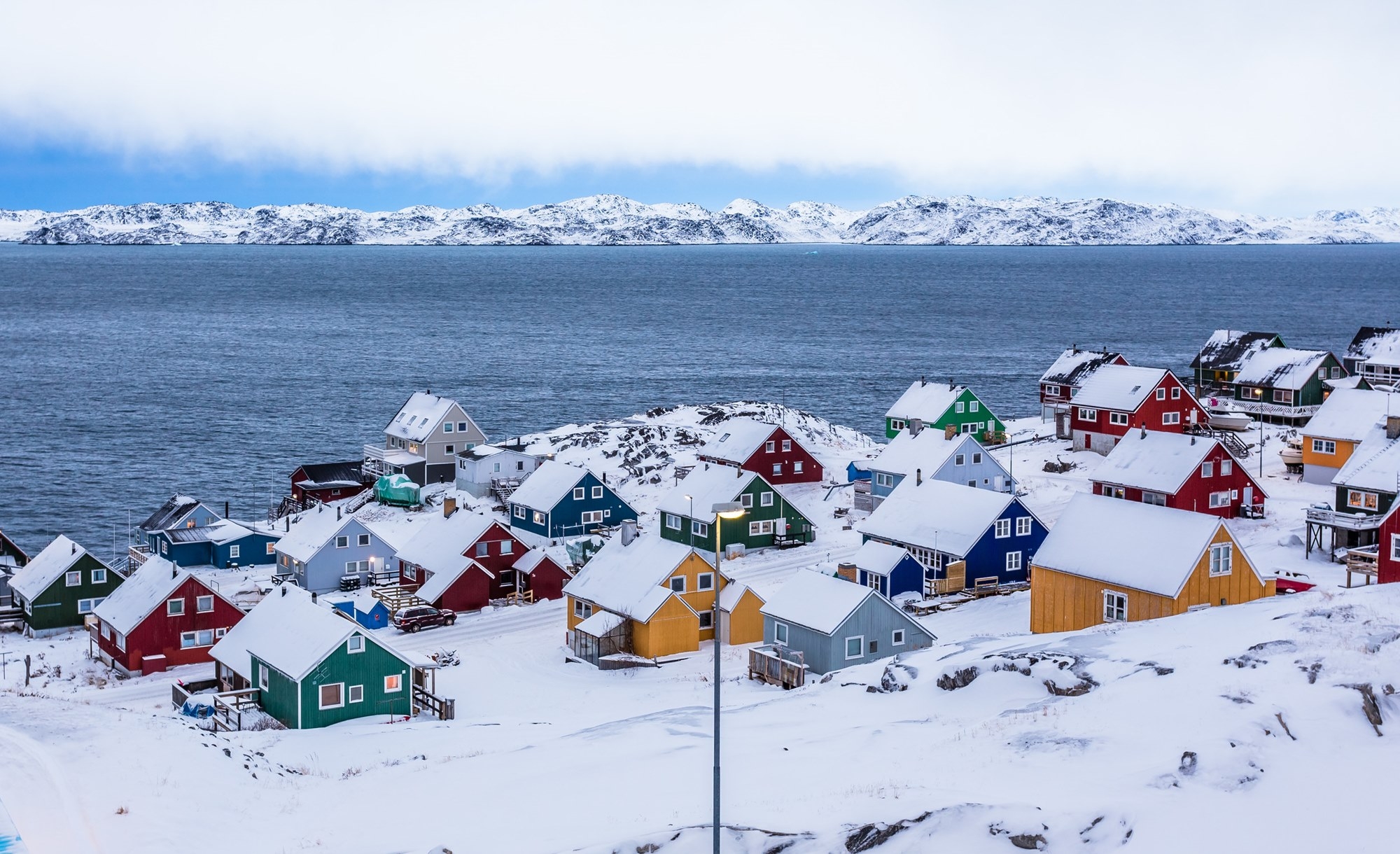 Colorful inuit houses among rocks and snow at the fjord in a sub 그린란드 전경. 123rf Colorful inuit houses among rocks and snow at the fjord in a sub 그린란드 전경. 123rf