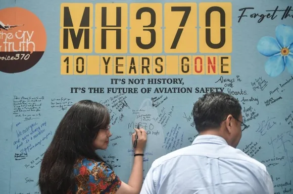 MH370 여객기 실종 10주년을 맞아 추모 글을 남기는 여성. AFP 연합뉴스