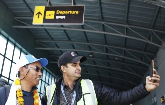 지난 20일 에베레스트 출발에 앞서 카트만두 공항에서 한 남성과 기념 촬영을 하는 카미 리타(왼쪽). AP 연합뉴스