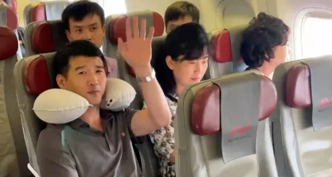 평양행 직항 항공기에서 카메라를 향해 손을 흔드는 북한 탑승객. 이번 운항은 북·러 관광 교류 재개를 표방했으나 실질 탑승객은 대부분 북측 관계자였던 것으로 전해졌다. 러시아1 방송 캡처