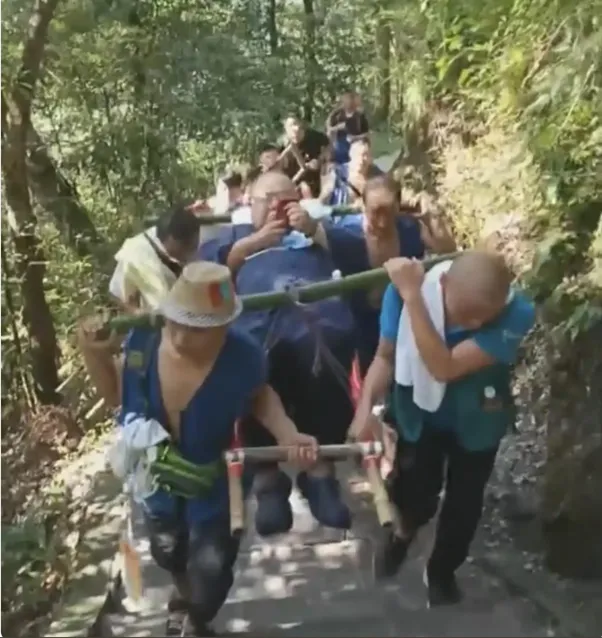 체중이 130kg이 넘는 중국 남성이 9명의 가마꾼에 둘러싸여 산을 오르고 있는 모습. 지무신문