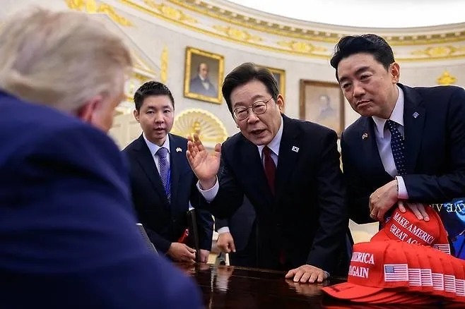 미 백악관이 사진 공유 사이트 ‘플리커’의 백악관 계정에 공개한 사진. 2025년 8월 25일 한미 정상회담 당시 이재명 대통령과 강훈식 비서실장이 책상에 손을 올린 채 트럼프 대통령과 논의하고 있다. 플리커 백악관 계정 미 백악관이 사진 공유 사이트 ‘플리커’의 백악관 계정에 공개한 사진. 2025년 8월 25일 한미 정상회담 당시 이재명 대통령과 강훈식 비서실장이 책상에 손을 올린 채 트럼프 대통령과 논의하고 있다. 플리커 백악관 계정