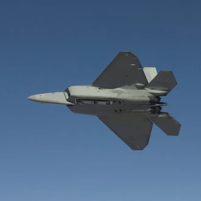 비행 중 무장창을 열어 탑재한 AIM-120 미사일이 보이는 F-22 랩터. 미 국방부 제공
