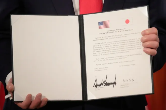 도널드 트럼프 미국 대통령이 28일(현지시간) 일본 도쿄 모토아카사카 영빈관에서 열린 서명식에서 다카이치 사나에 일본 총리와 함께 서명 문서를 들어 보이고 있다. AP 연합뉴스
