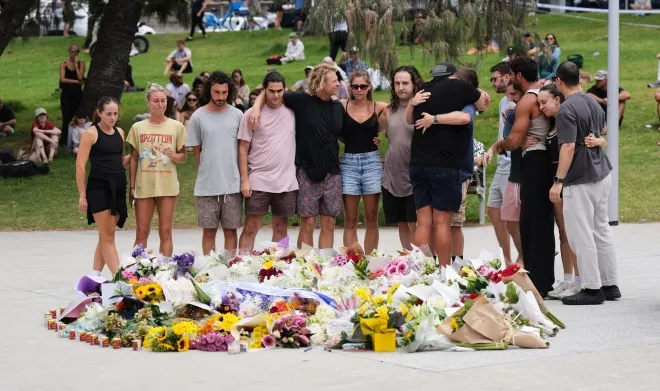 15일 시드니 본다이 비치 추모 장소에 헌화하고 추모하는 시민들. AP 연합뉴스