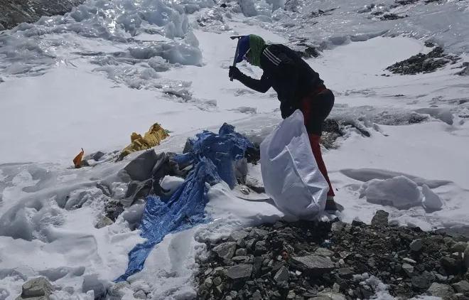 에베레스트에 얼어붙은 쓰레기를 도구를 사용해 치우는 모습. AP 연합뉴스 자료사진