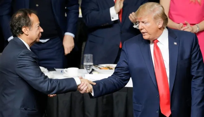 도널드 트럼프 미국 대통령(오른쪽)이 2016년 11월 뉴욕 이코노믹클럽 행사에서 헤지펀드 억만장자 존 폴슨과 악수하고 있다. AP 연합뉴스