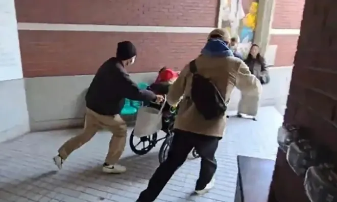 병원 복도에서 가족들이 102세 왕 씨가 탄 휠체어를 밀어 이동시키고 있다.