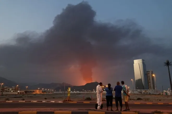 아랍에미리트(UAE) 후자이라 산업단지에서 폭발이 발생한 뒤 연기가 솟아오르는 모습을 외국인 노동자들이 바라보고 있다. AFP연합뉴스