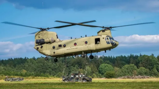 미 육군 CH-47 치누크가 외부 화물 수송 훈련을 위해 지상 차량을 와이어로 연결한 채 비행하고 있다. 미 육군 제공
