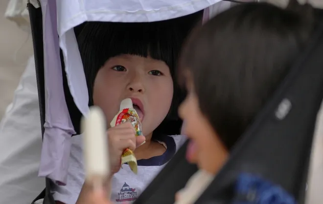 중국 베이징에서 지난달 31일 어린이들이 무더위 속 유모차에 앉아 아이스크림을 먹고 있다. 중국은 출생아 수 감소에 대응해 출산 장려 정책을 강화하고 있지만 실효성 논란이 이어지고 있다. AP 연합뉴스