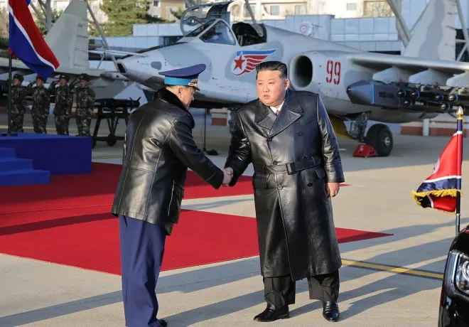 김정은 북한 국무위원장이 지난해 11월 28일 제2공군사단 59길영조영웅연대 갈마비행장에서 열린 북한 공군 창설 80주년 기념행사에서 김광혁 공군사령관과 악수하고 있다. 조선중앙통신 연합뉴스