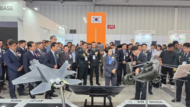 2026 대한민국 국방산업발전대전 KAI 부스에서 관계자들이 KF-21 계열 전투기 모형과 소형무장헬기(LAH) 관련 전시물을 살펴보고 있다. KAI 제공