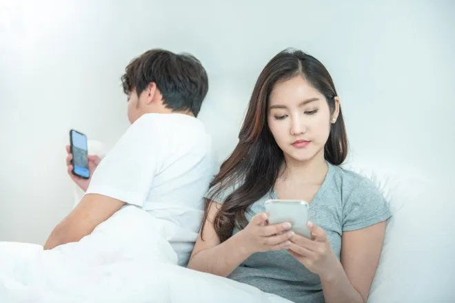 서로 등을 돌린 채 각자 스마트폰을 사용하는 남녀. 중국은 AI 동반자 서비스가 현실의 인간관계를 훼손하거나 이용자의 정서적 의존을 키우지 못하도록 규제를 강화했다. 123rf
