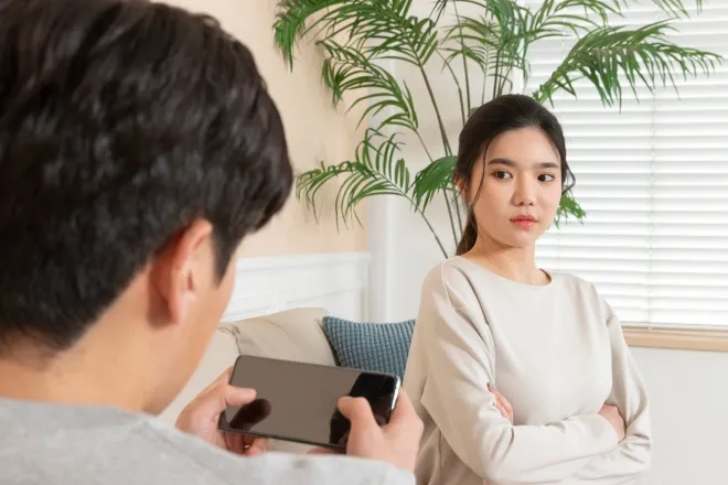 남편이 스마트폰을 사용하는 동안 불만스러운 표정을 짓는 아내의 모습. 사진은 기사 내용과 직접적인 관련이 없는 자료 이미지. 123RF