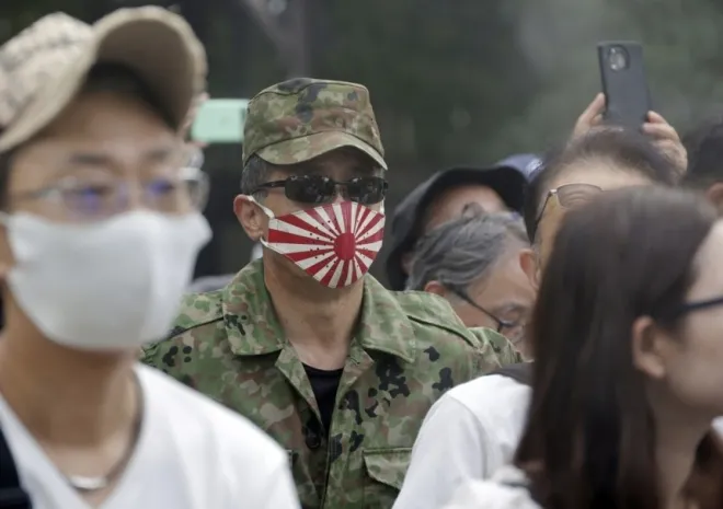 2026년 8월 15일 일본 도쿄 야스쿠니 신사에서 군복 차림의 한 남성이 욱일기가 그려진 마스크를 쓰고 있다. EPA 연합뉴스