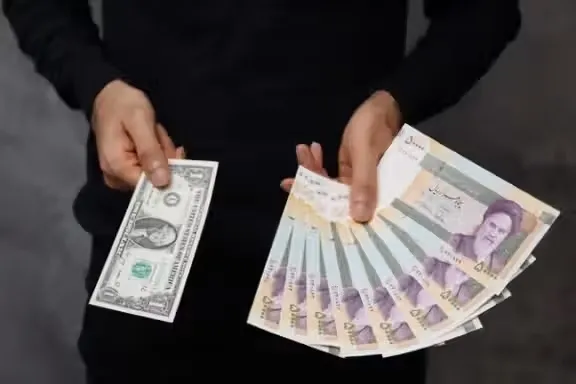 달러화와 이란 리알 지폐를 각각 손에 든 모습. 리알화 가치가 떨어지면서 테헤란 일부 고급 부동산 시장에서는 매매가나 임대료를 아예 달러 기준으로 제시하는 사례도 나타나고 있다. 이란 인터내셔널 캡처